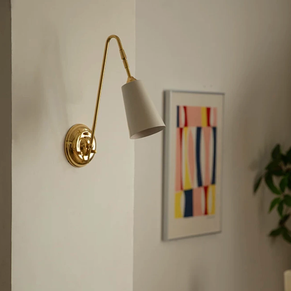 Vintage brass wall light beside framed wall art