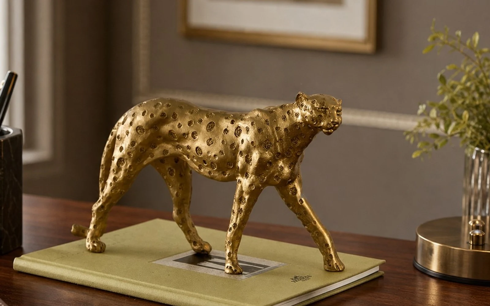 Antique gold leopard sculpture styled on a desk with warm room decor