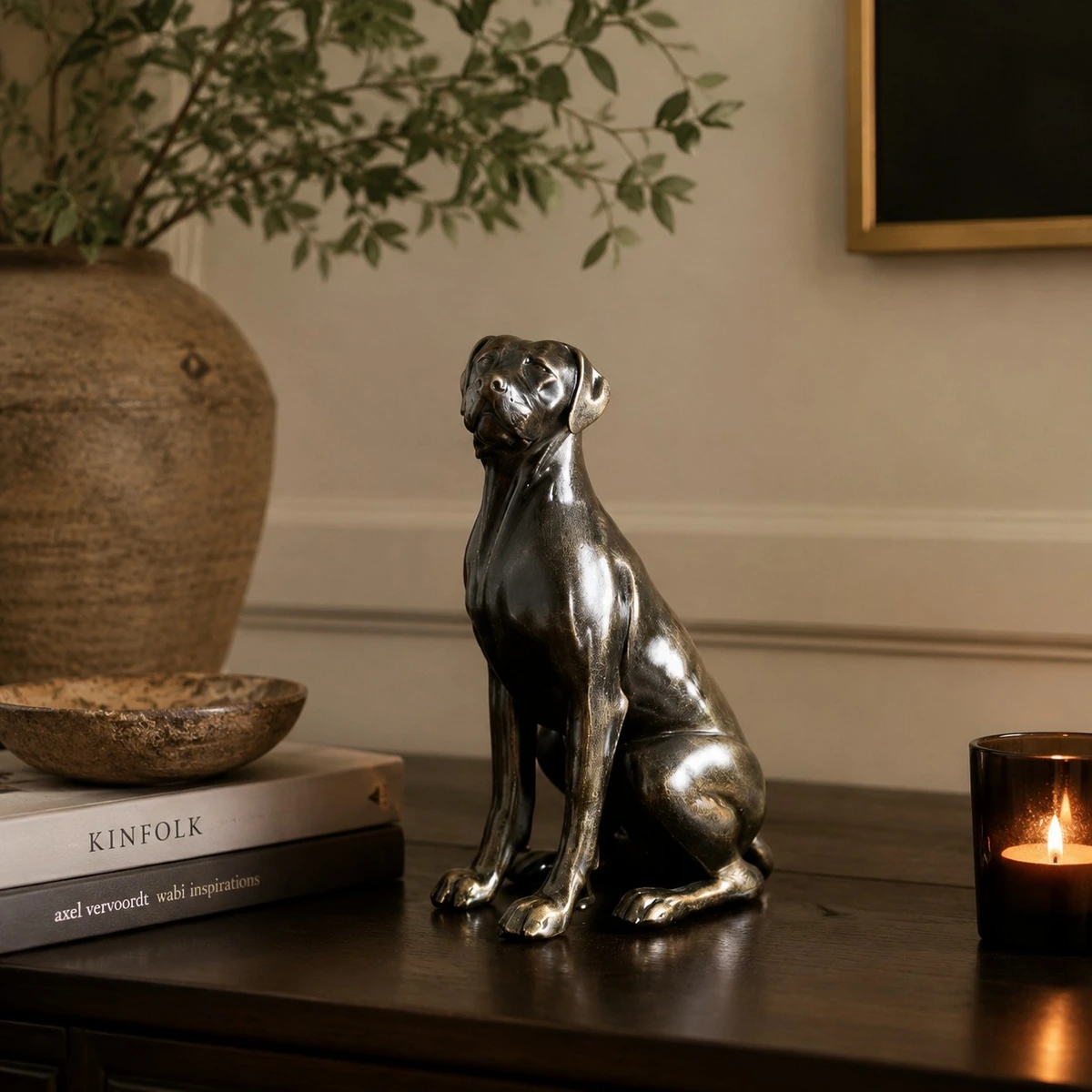 Black dog sculpture on table with candle