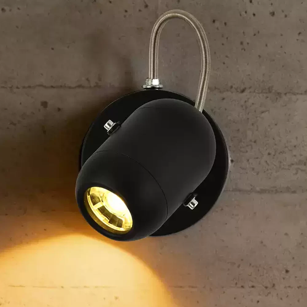Black wall spotlight creating a warm focused light beam