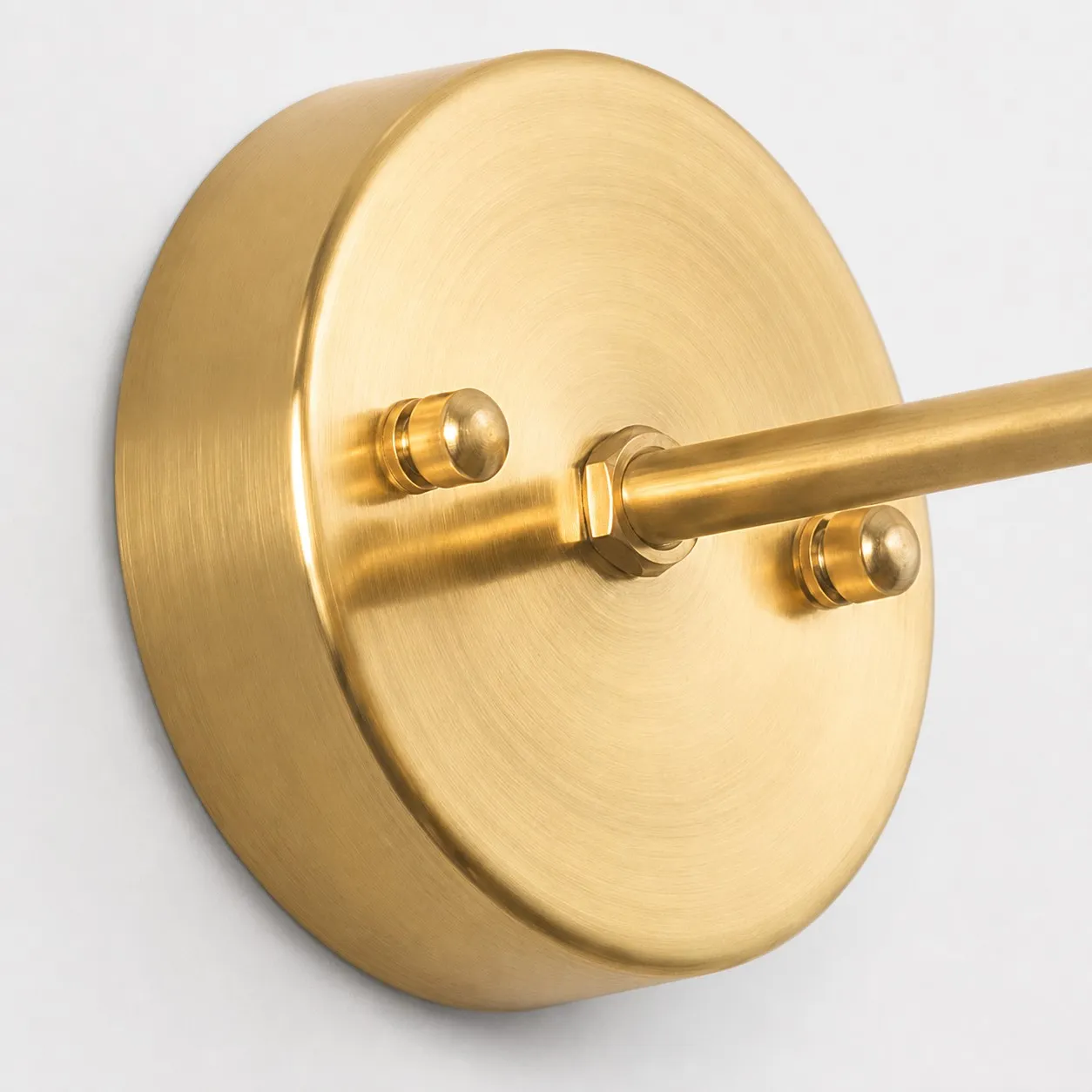 Brushed brass circular wall plate and arm detail